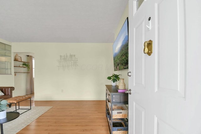 hall featuring baseboards and light wood-type flooring