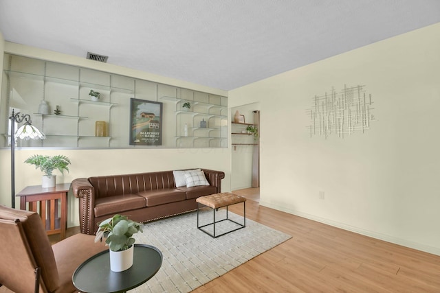 living room with baseboards, wood finished floors, and visible vents