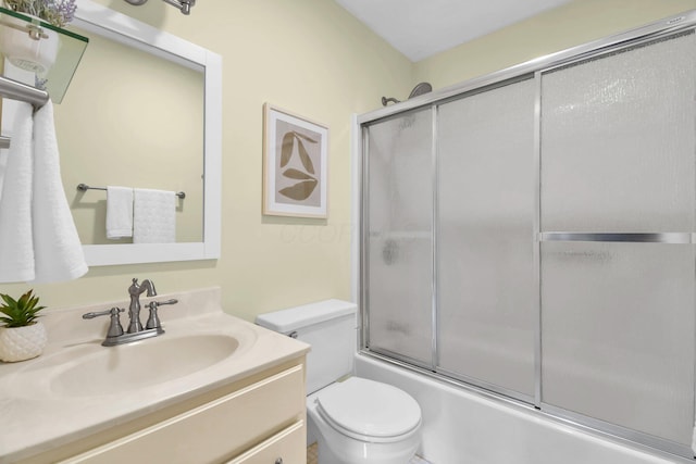 full bathroom featuring toilet, combined bath / shower with glass door, and vanity