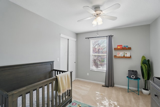 bedroom featuring ceiling fan, baseboards, a closet, and light colored carpet