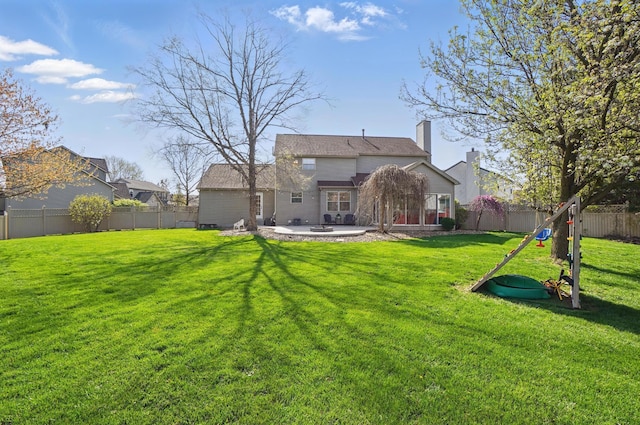 rear view of house featuring a yard, a fenced backyard, and a patio