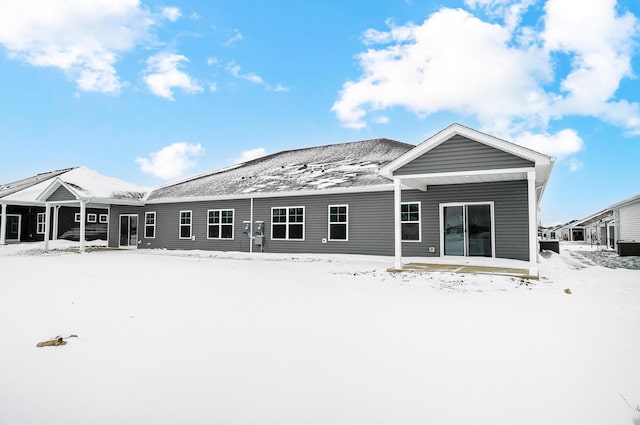view of snow covered back of property