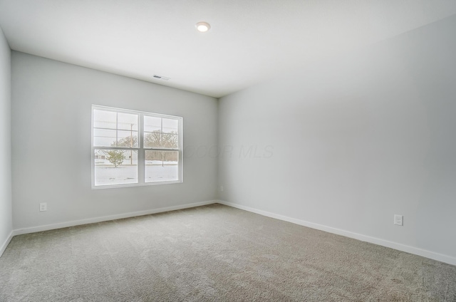 carpeted empty room with baseboards and visible vents