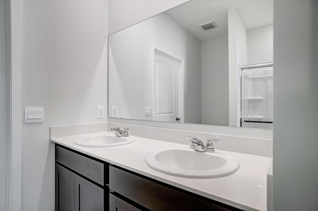 full bath featuring a sink, visible vents, and double vanity