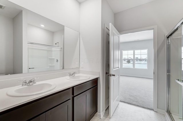 full bathroom featuring visible vents, a shower with door, a sink, and double vanity