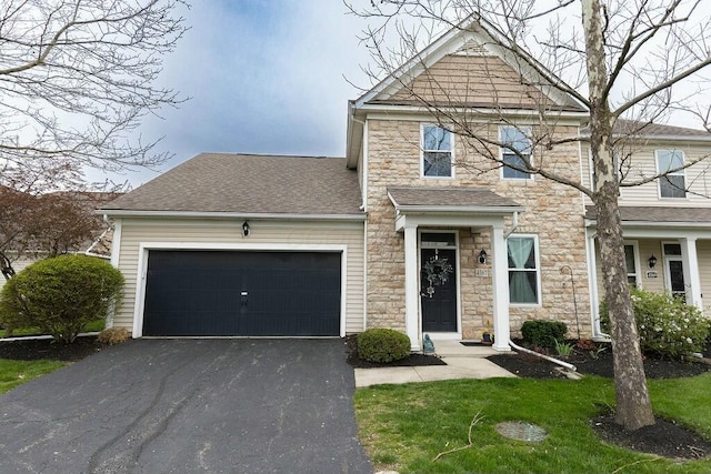 view of front of house featuring a garage, aphalt driveway, a shingled roof, and stone siding