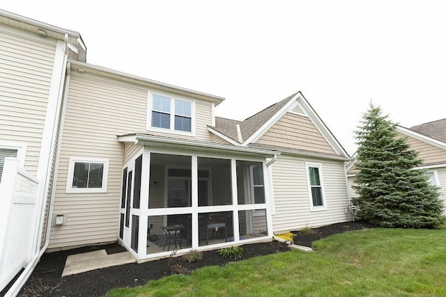 back of house featuring a sunroom and a yard