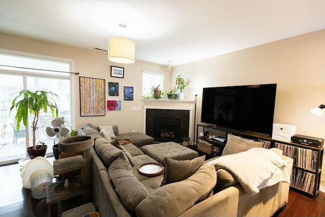 living room featuring visible vents, dark wood-style flooring, and a fireplace