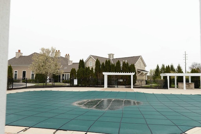 view of swimming pool with a pergola and fence