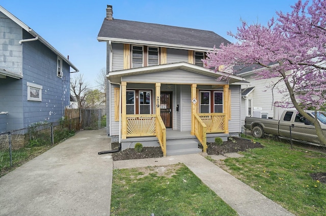 219 Belvidere Ave, Columbus, OH 43223 - view of front of house featuring a chimney, a front lawn, fence, and covered porch