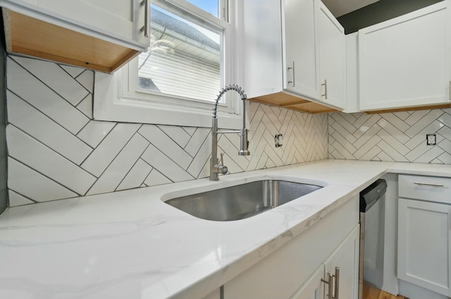 219 Belvidere Ave, Columbus, OH 43223 - kitchen featuring stainless steel dishwasher, a sink, backsplash, white cabinetry, and light stone countertops