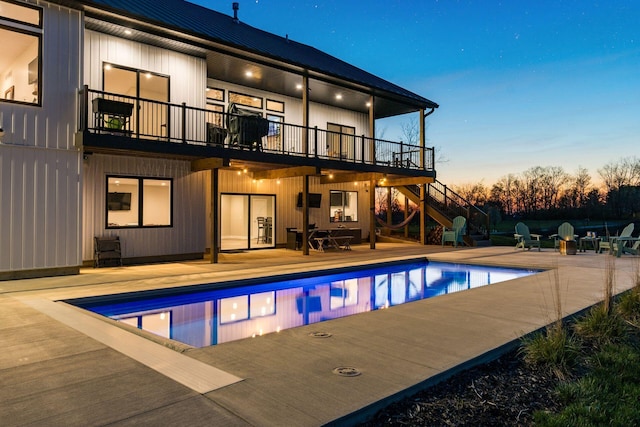 back of property featuring an outdoor pool, a deck, stairs, and a patio