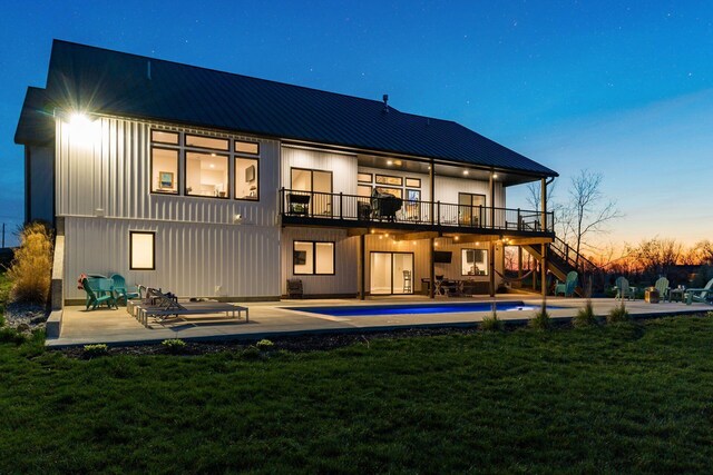 back of property featuring a yard, stairway, a patio area, and metal roof