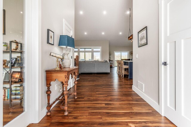 hallway with baseboards, dark wood-type flooring, visible vents, and recessed lighting