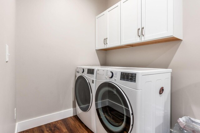 laundry area with cabinet space, baseboards, dark wood-type flooring, and separate washer and dryer