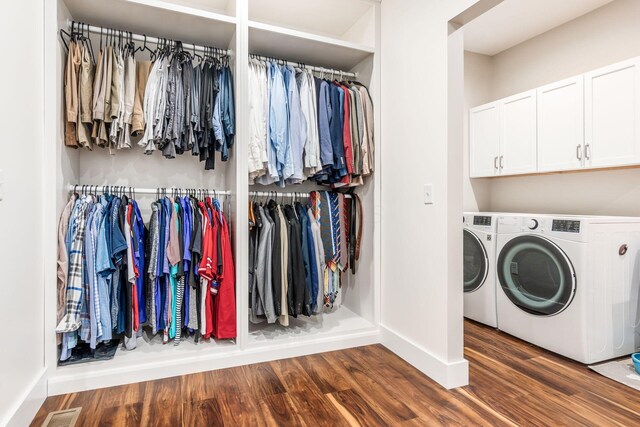 laundry area with visible vents, baseboards, wood finished floors, independent washer and dryer, and cabinet space