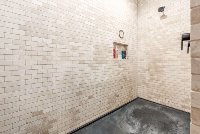 bathroom featuring concrete floors and tiled shower