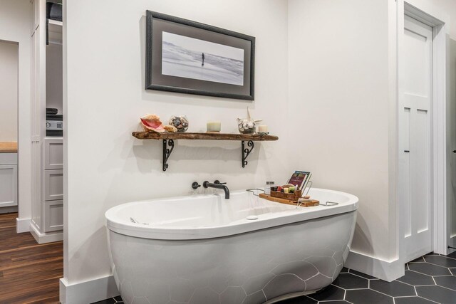 full bathroom featuring baseboards and a soaking tub