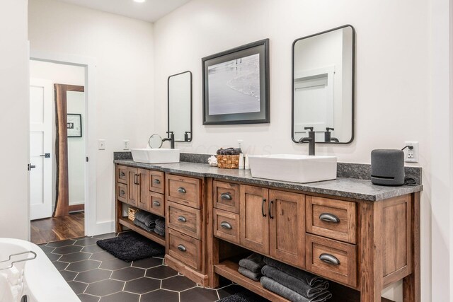 bathroom with tile patterned floors, a sink, and double vanity