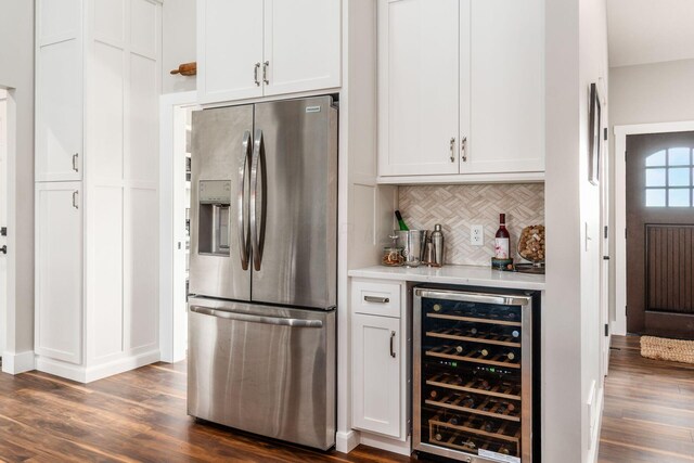bar featuring a dry bar, stainless steel fridge, dark wood finished floors, backsplash, and beverage cooler