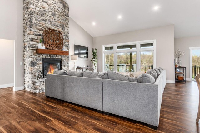 living room with baseboards, a fireplace, high vaulted ceiling, and dark wood-style flooring