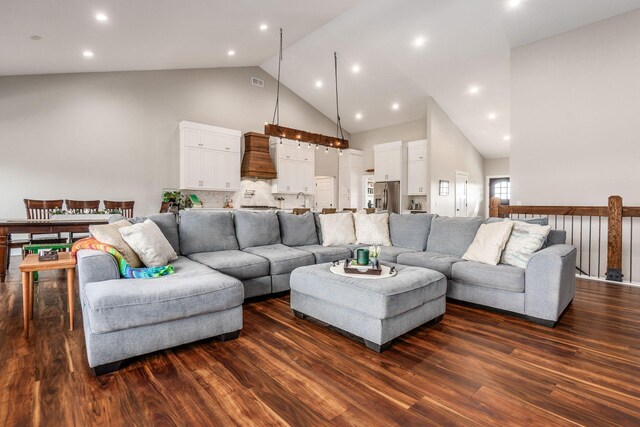 living room featuring visible vents, high vaulted ceiling, and dark wood finished floors