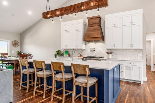 kitchen featuring dark wood-type flooring, vaulted ceiling, and custom exhaust hood