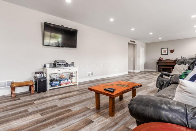 living room featuring wood finished floors, visible vents, and recessed lighting
