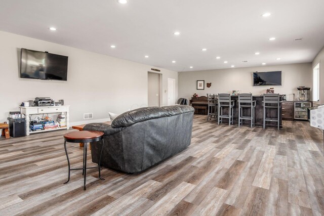 living room featuring recessed lighting, wood finished floors, and visible vents
