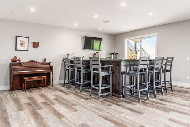 bar featuring recessed lighting, wood finished floors, and a dry bar