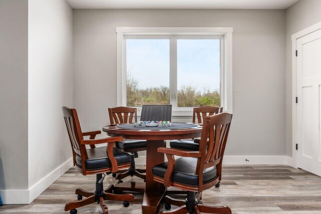 dining room featuring plenty of natural light, baseboards, and wood finished floors