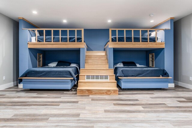 bedroom with baseboards, wood finished floors, visible vents, and recessed lighting