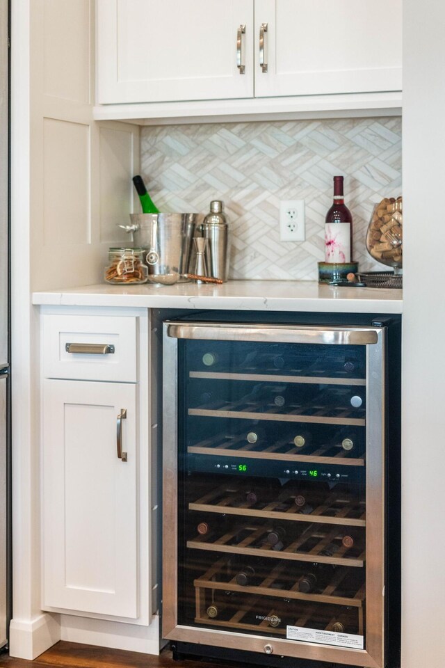 bar featuring a dry bar, tasteful backsplash, and beverage cooler