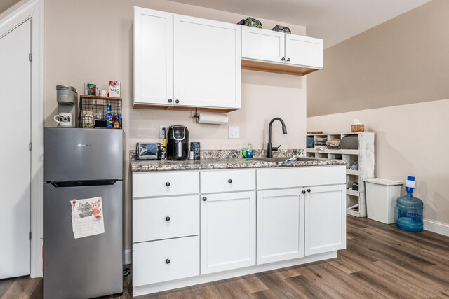 kitchen featuring white cabinets, freestanding refrigerator, dark wood-type flooring, and a sink