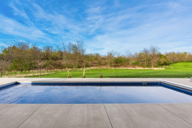outdoor pool featuring a yard