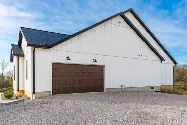 view of property exterior featuring crawl space, a garage, metal roof, gravel driveway, and a standing seam roof