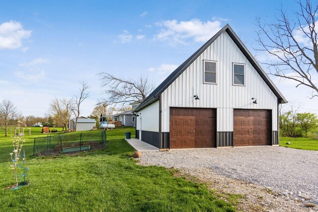 view of side of property featuring a lawn, board and batten siding, an outdoor structure, fence, and a garage