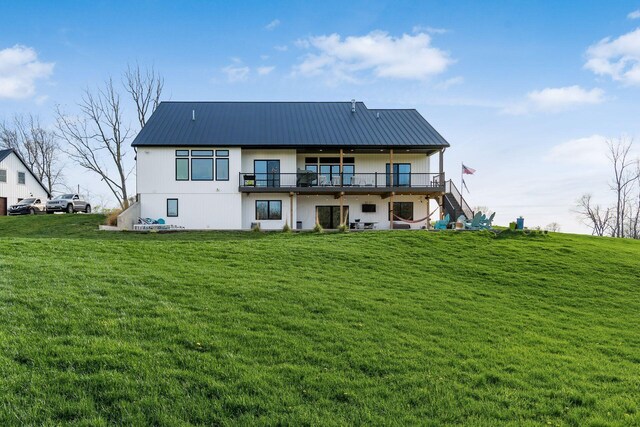 back of property featuring metal roof, a lawn, and stairway
