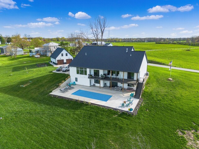 back of property with metal roof, a wooden deck, a lawn, stairs, and a patio