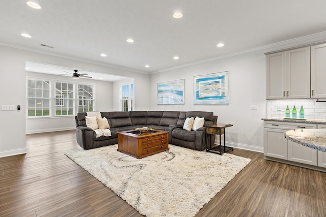 living area featuring crown molding, baseboards, recessed lighting, and dark wood finished floors