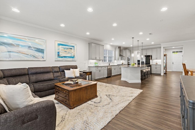 living area featuring recessed lighting, ornamental molding, and dark wood-type flooring