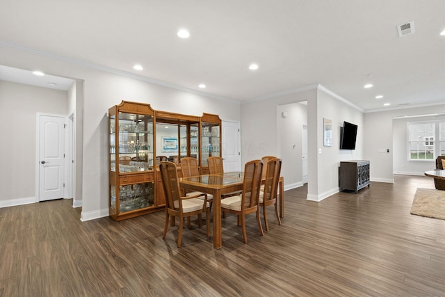 dining space with visible vents, ornamental molding, baseboards, and wood finished floors
