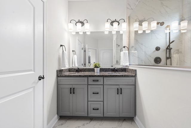 full bath featuring double vanity, a walk in shower, baseboards, and marble finish floor