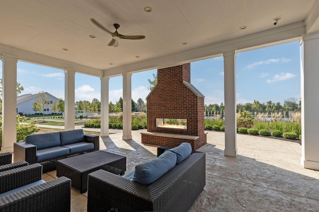 view of patio with ceiling fan and an outdoor living space with a fireplace
