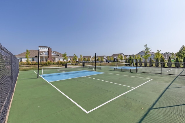 view of sport court with fence and a residential view