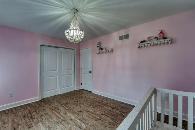 779 Millstone Ln, Mount Vernon, OH 43050 - unfurnished bedroom featuring baseboards, visible vents, an inviting chandelier, wood finished floors, and a closet