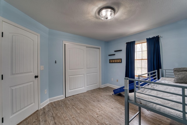 779 Millstone Ln, Mount Vernon, OH 43050 - bedroom featuring baseboards, wood finished floors, a textured ceiling, and a closet