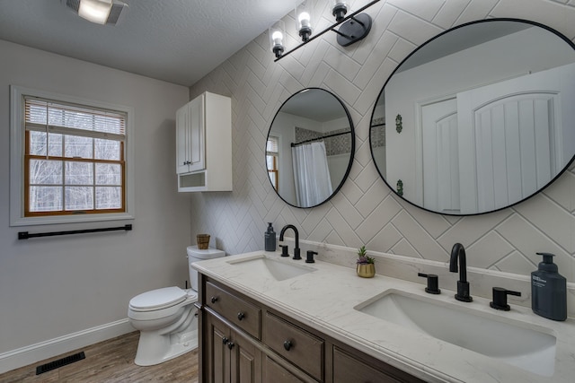 779 Millstone Ln, Mount Vernon, OH 43050 - full bathroom featuring toilet, wood finished floors, a sink, and tasteful backsplash