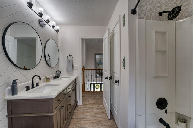779 Millstone Ln, Mount Vernon, OH 43050 - full bathroom featuring double vanity, wood finished floors, a textured ceiling, and a sink