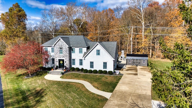 779 Millstone Ln, Mount Vernon, OH 43050 - view of front of home with stone siding, an outbuilding, a front yard, and concrete driveway